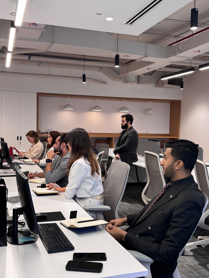 About Group of professionals in a modern office collaborating at computer desks.
