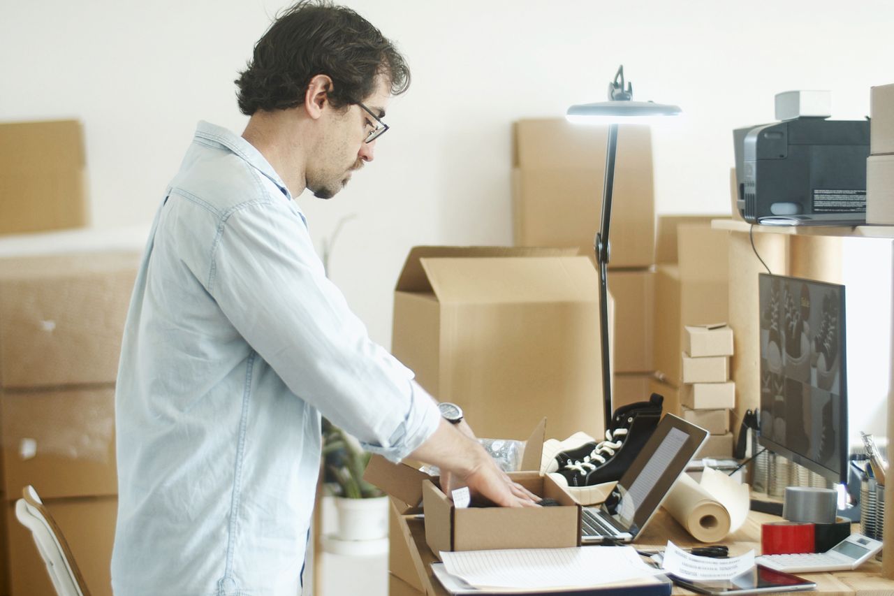 Home Businessman packing products in a home office for an online store startup.